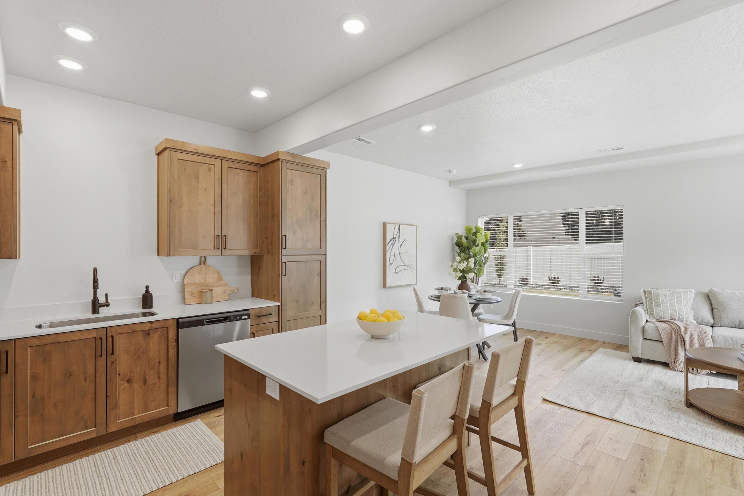 Kitchen featuring wood-finish cabinetry, stainless steel dishwasher, and a white countertop