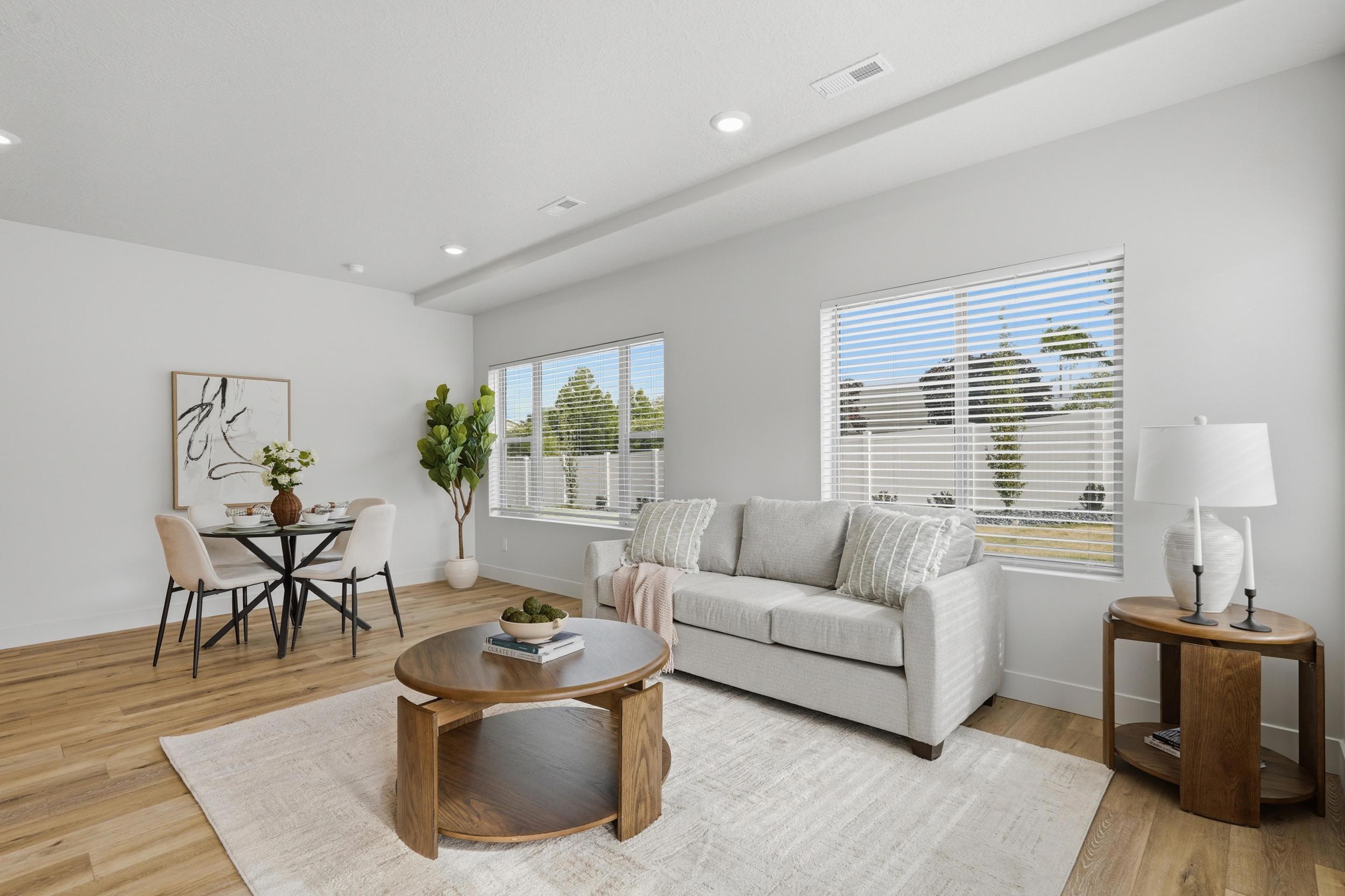 Open-concept living area featuring light wood-finish flooring, recessed lighting, and ample natural illumination from multiple windows