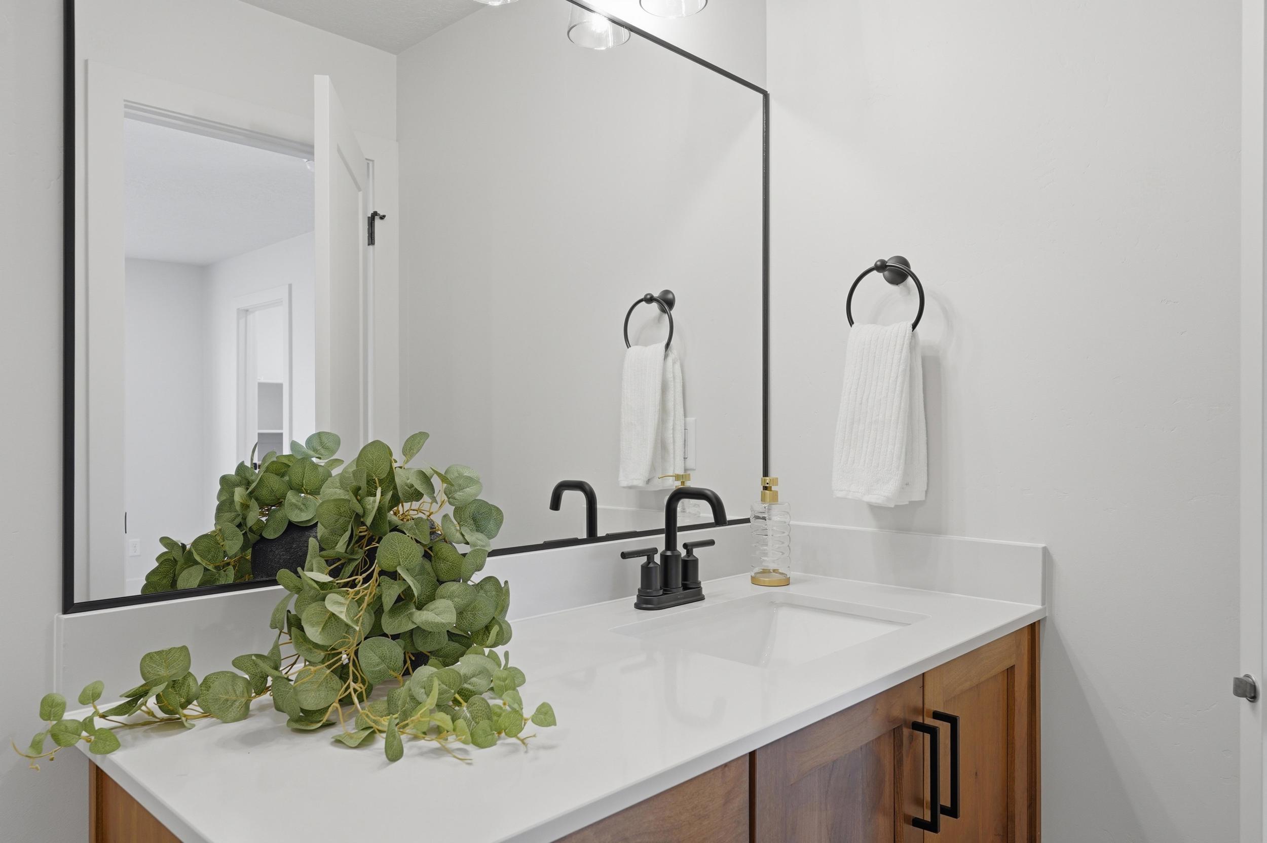 Contemporary vanity featuring wood-finish cabinetry and a white countertop