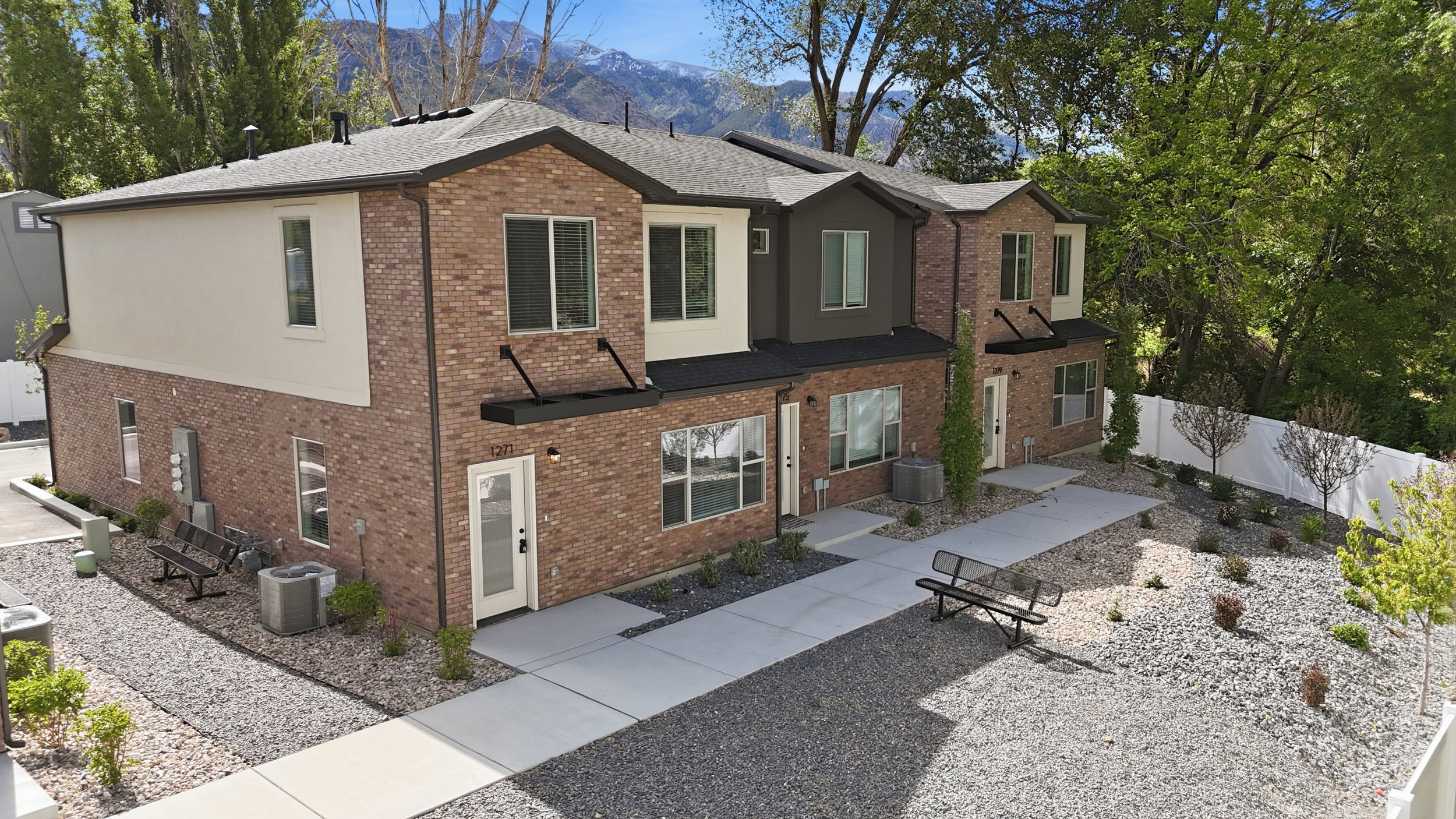 Modern townhome exterior featuring brick and stucco finishes