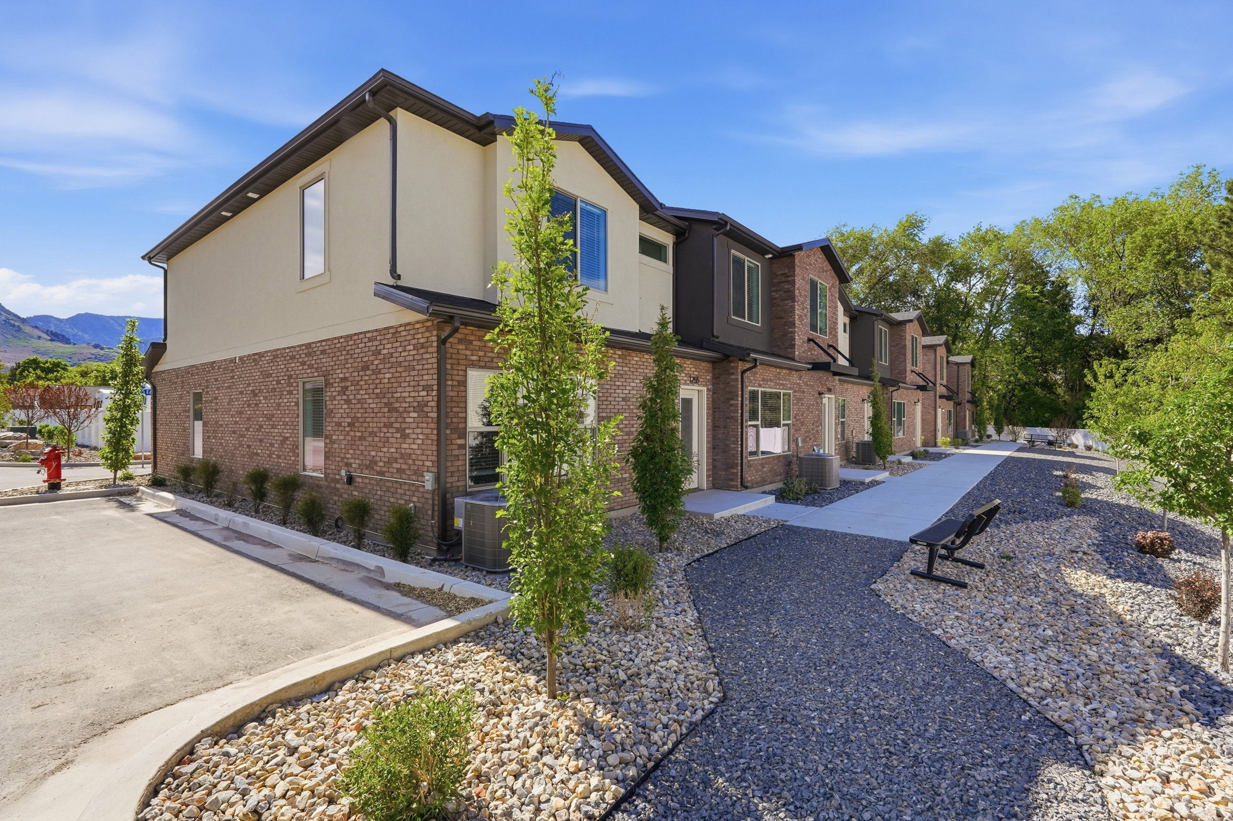 Contemporary townhome exterior featuring brick and stucco finishes