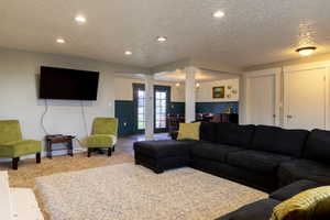 Open concept living area featuring recessed lighting, a neutral carpeted floor, and a distinct two-tone wall treatment