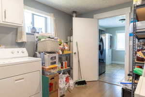 Laundry area featuring light wood-finish flooring and a single-pane window