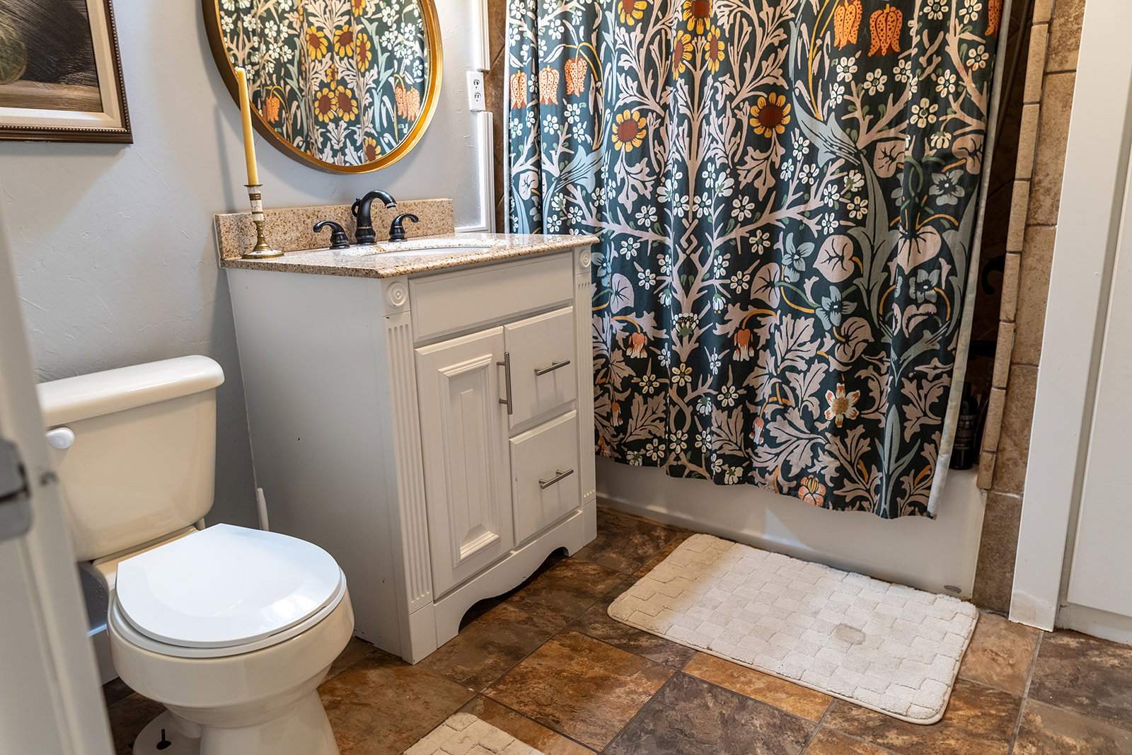 Bathroom featuring a white vanity with a granite-style countertop, an undermount sink, and a dark-toned faucet