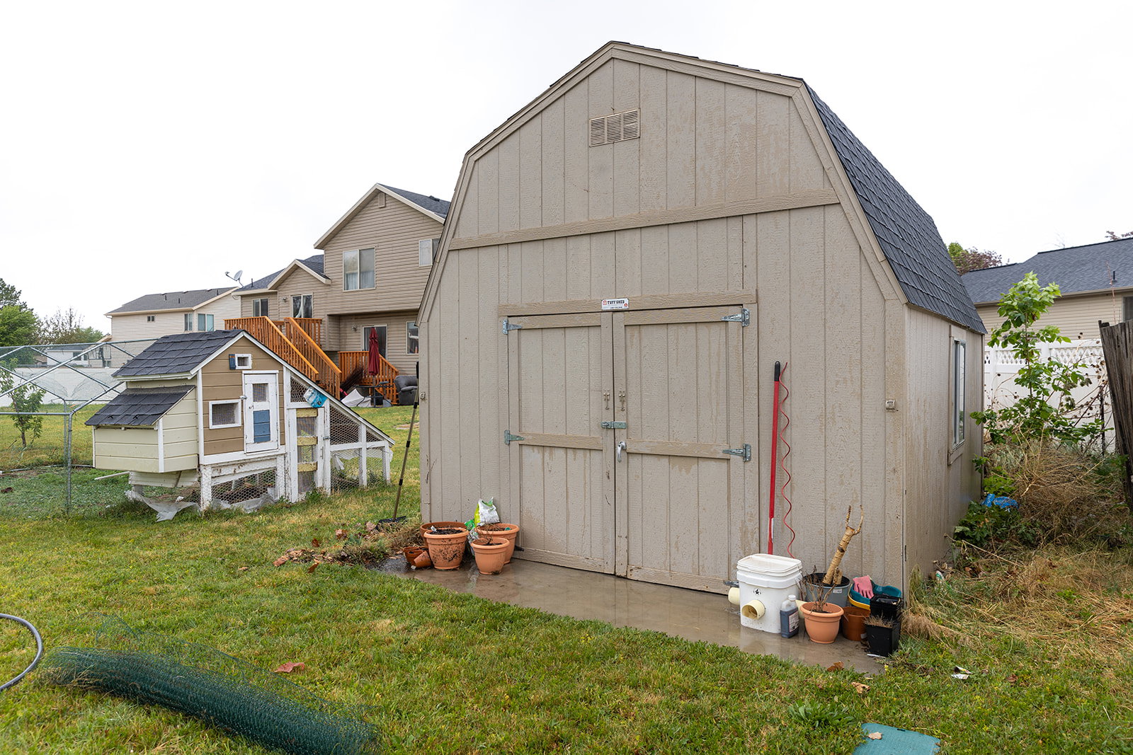 Gambrel roof storage shed with double barn doors and side window