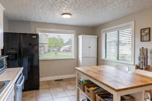 Kitchen dining area featuring a light wood-finish island, white base, and integrated storage