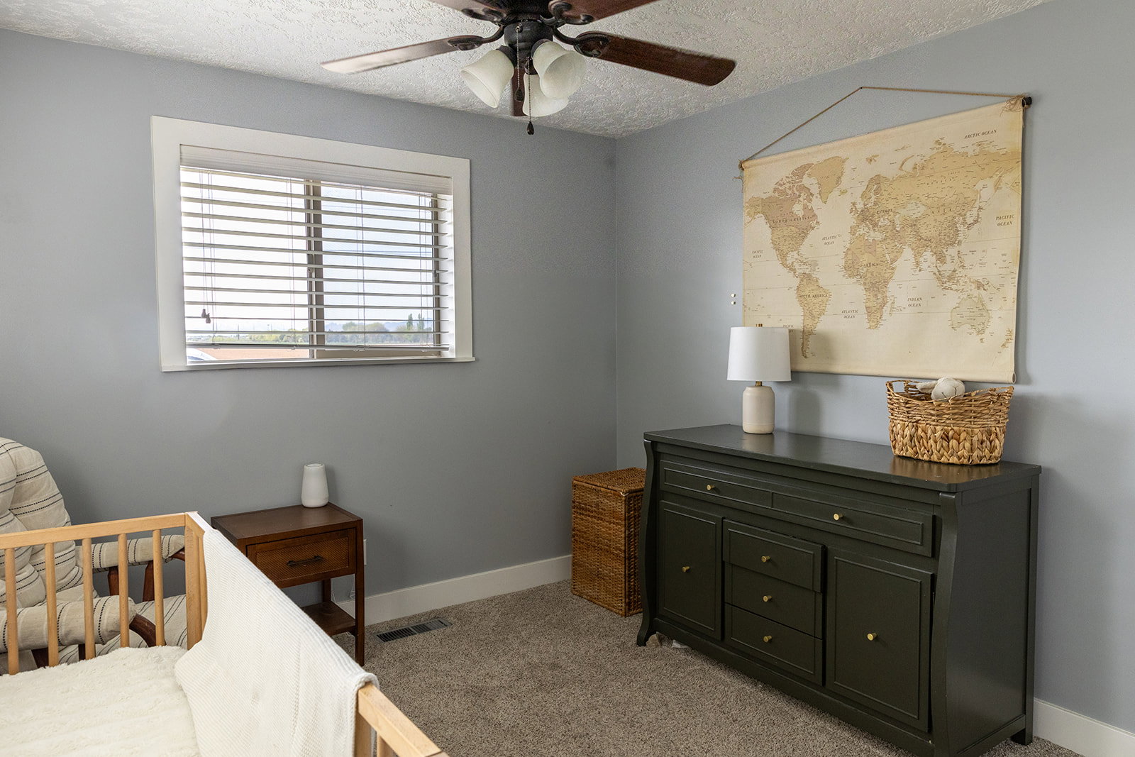 Room featuring a window with horizontal blinds, a ceiling fan with light fixture, and neutral gray wall paint