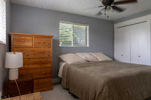Bedroom featuring light gray walls, a window with horizontal blinds, and a ceiling fan with integrated lighting