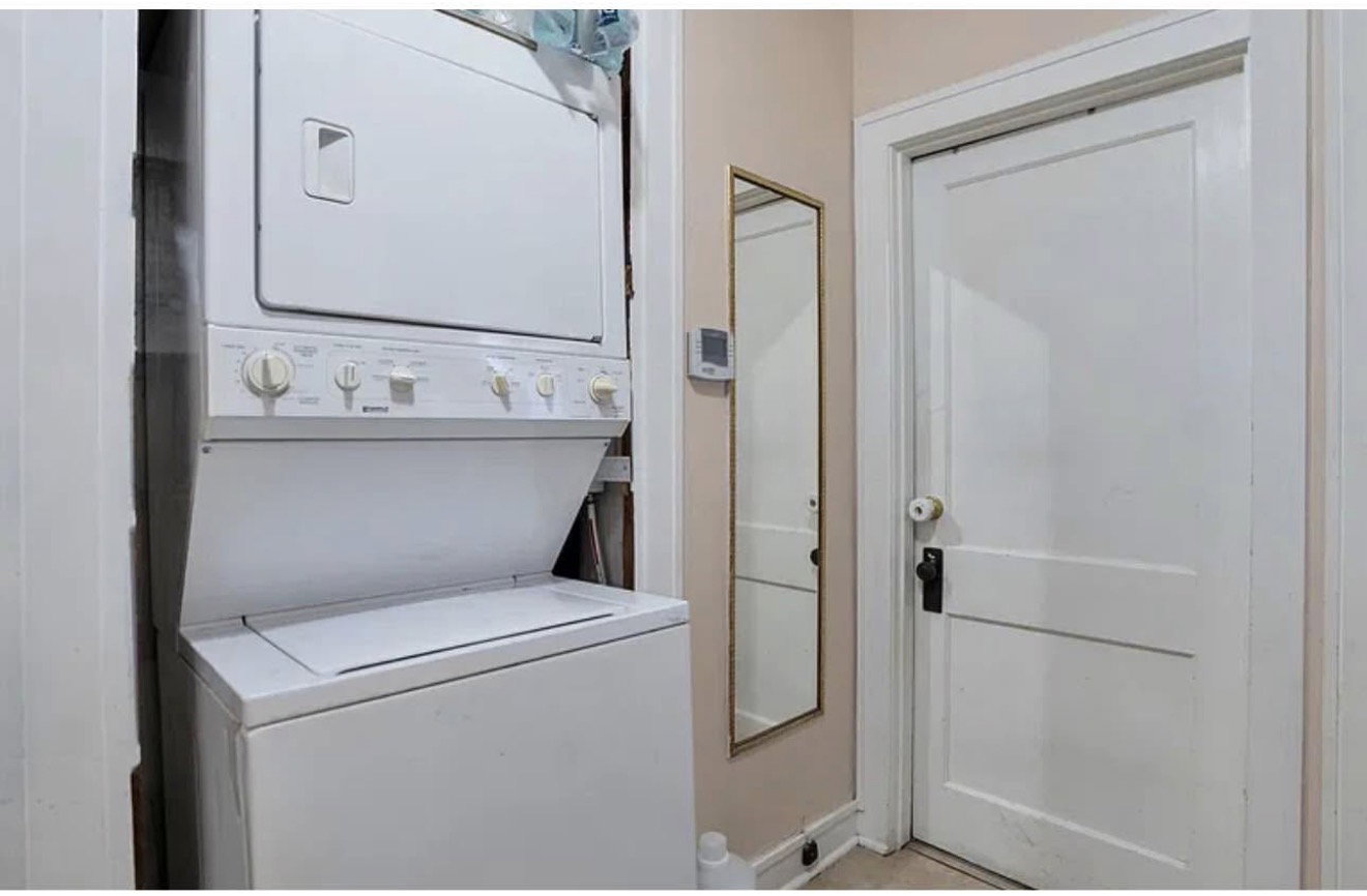 Dedicated laundry area featuring a stacked washer and dryer unit