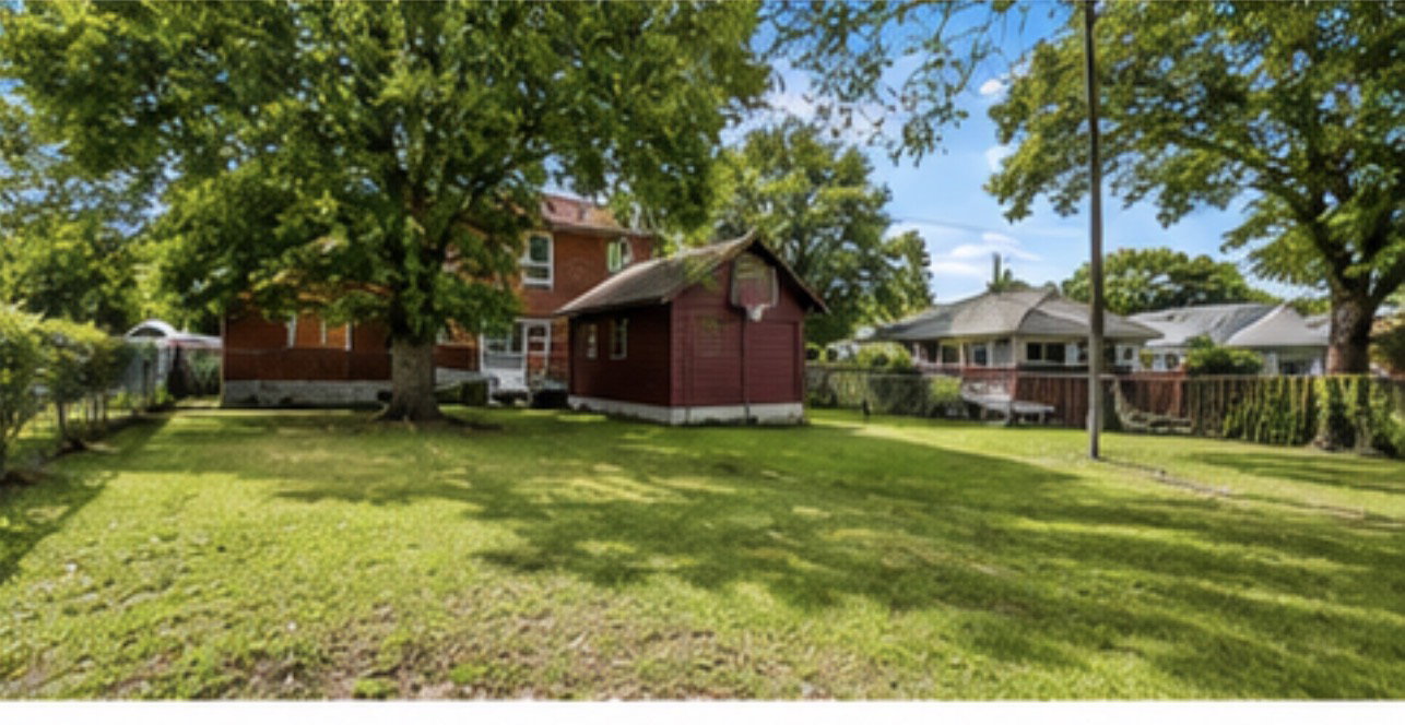 Expansive green lawn with mature shade trees