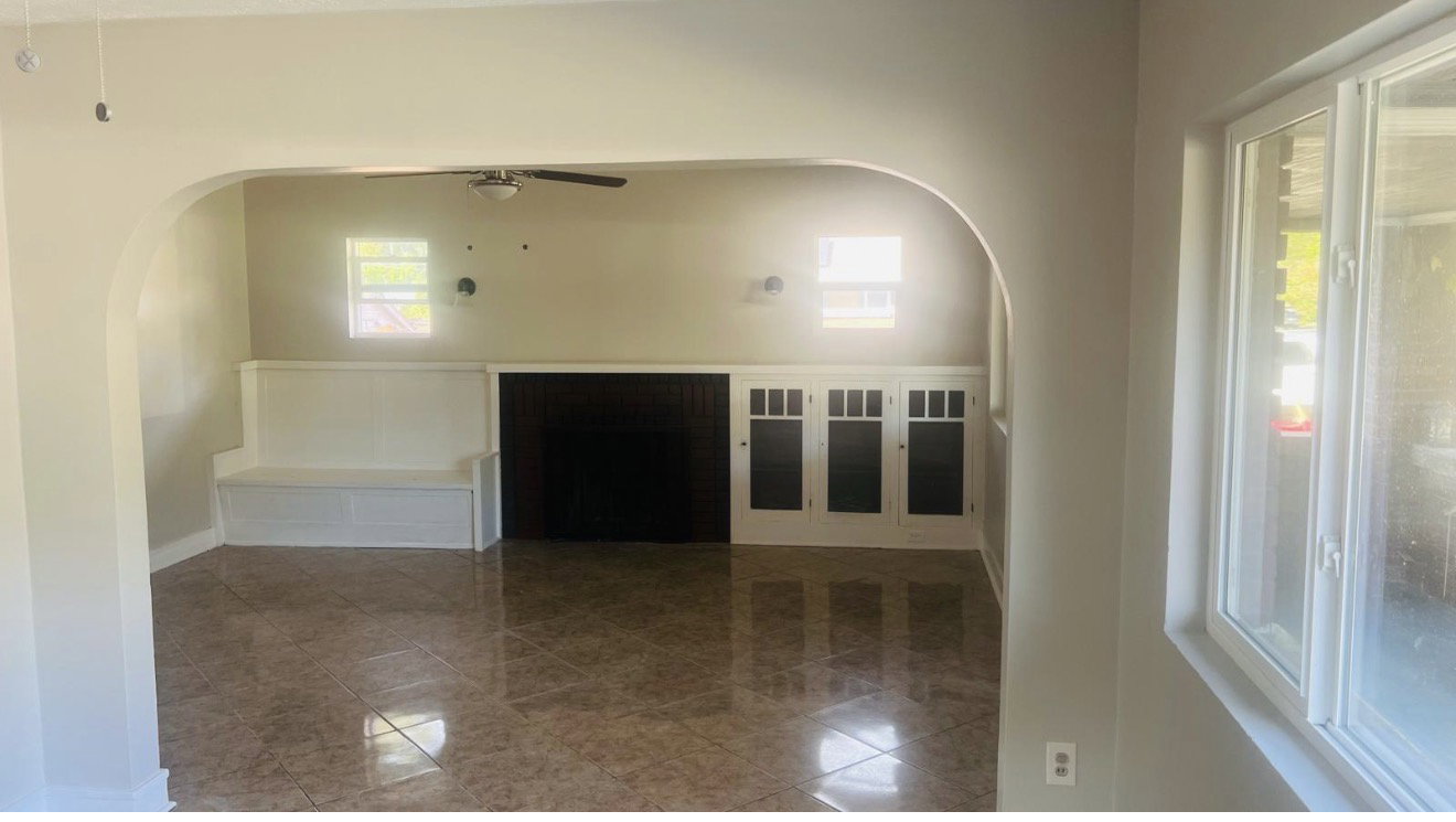 Interior space with arched doorway, tile flooring, built-in bench seating, and built-in cabinetry with dark panels