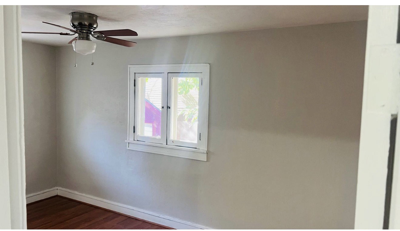 Interior room featuring neutral wall tones and wood-finish flooring