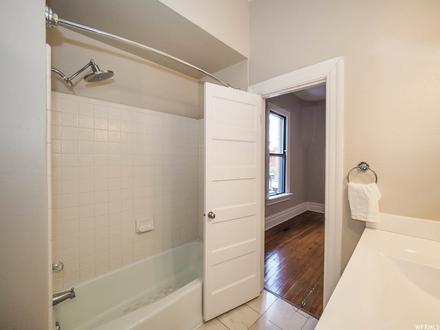Tub and shower combination with white subway tile surround, curved shower rod, and chrome fixtures