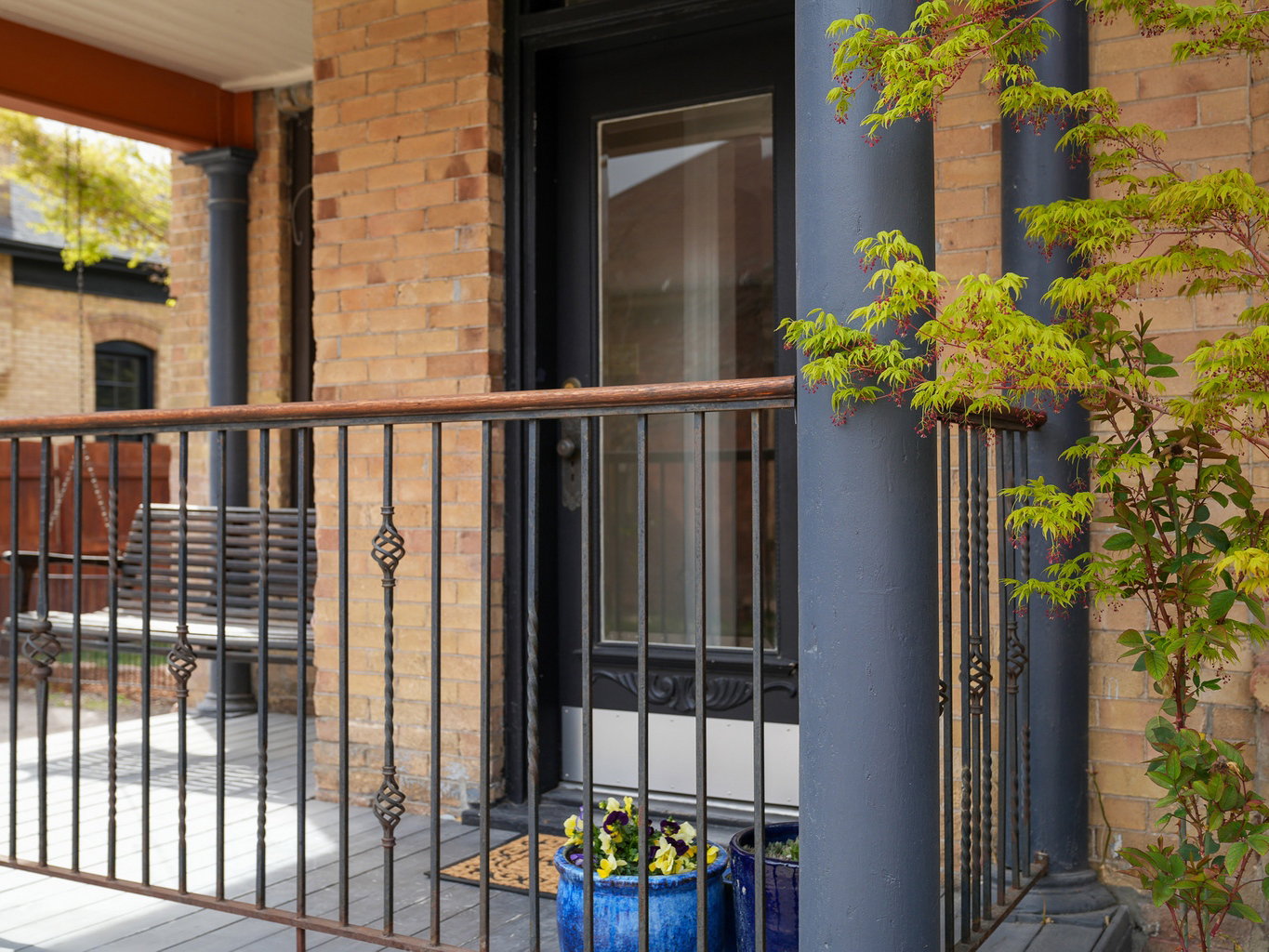 Brick facade with an ornate black entry door featuring a glass pane