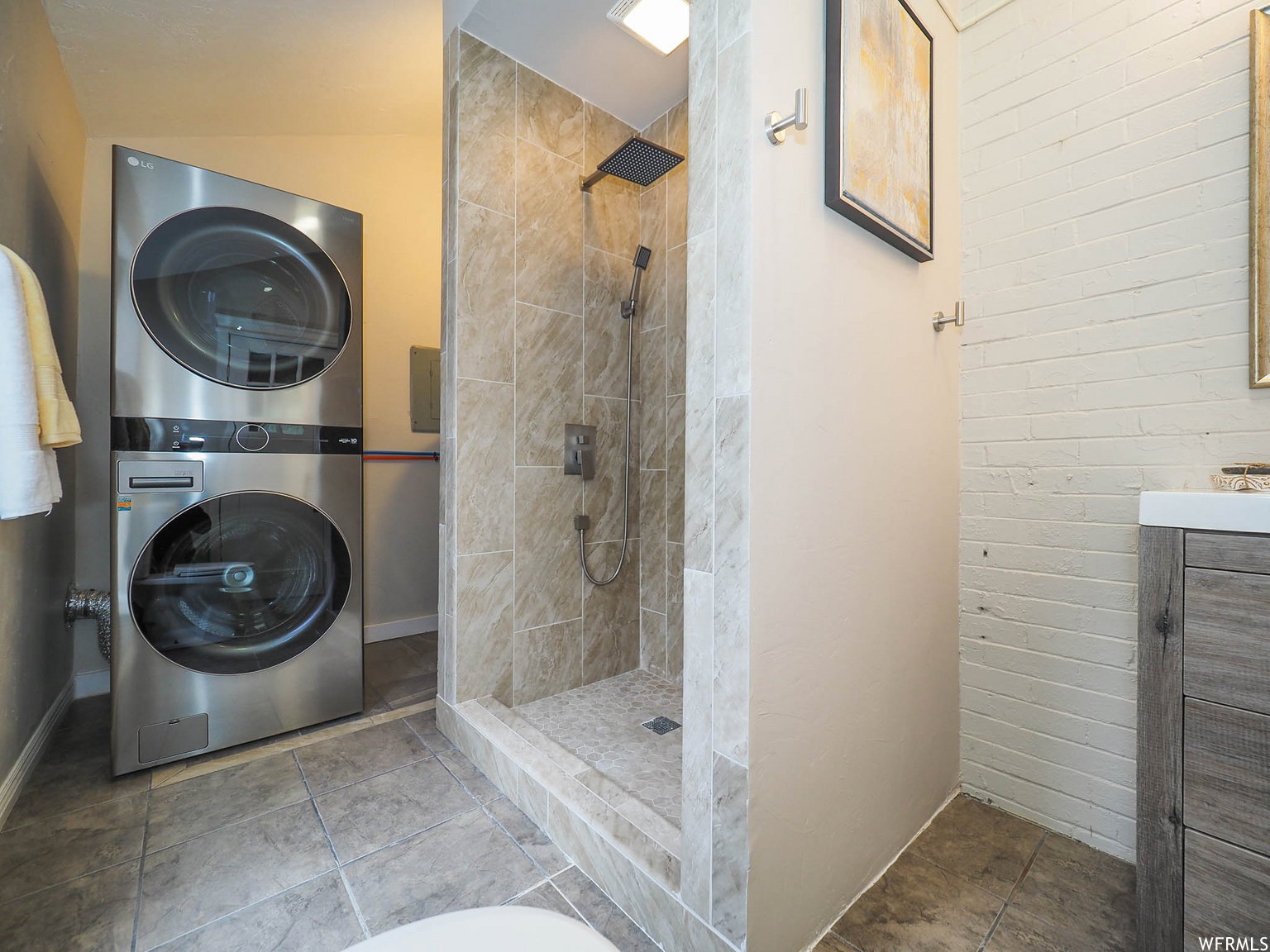 Shower with rain showerhead and handheld sprayer, tiled walls and floor, and glass enclosure