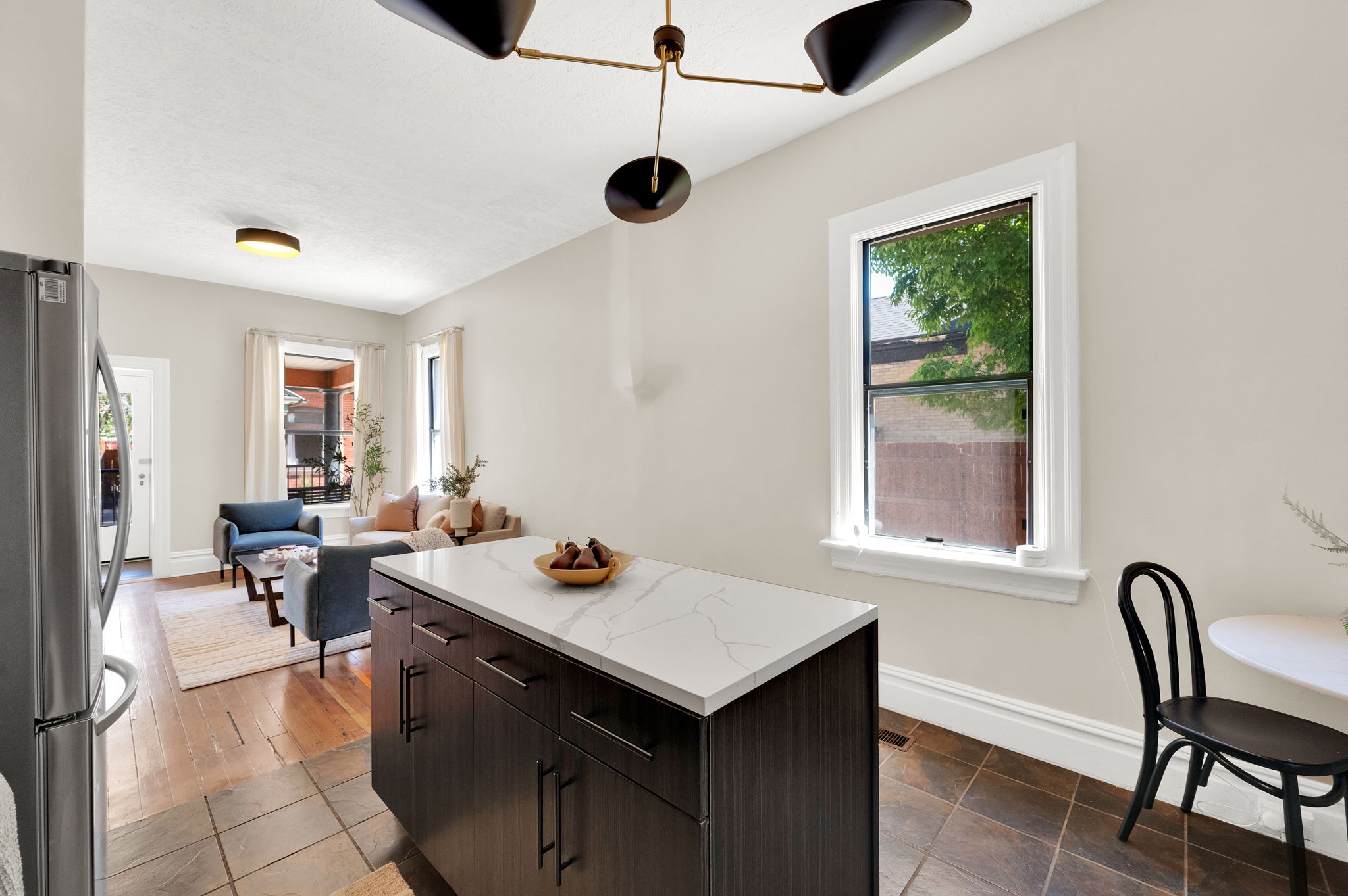 Kitchen island with a white veined countertop, ample cabinetry, and modern hardware