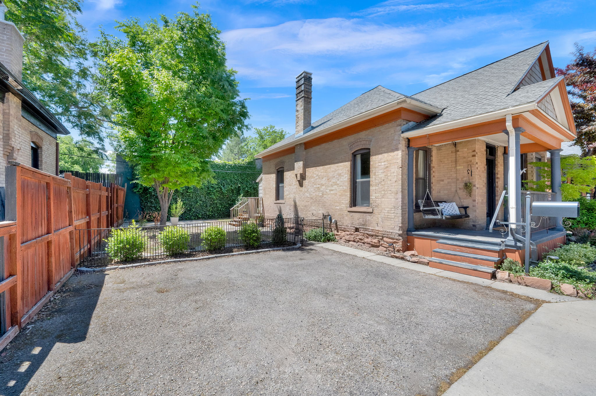 Brick exterior featuring a covered porch with dark gray flooring and rust-toned trim