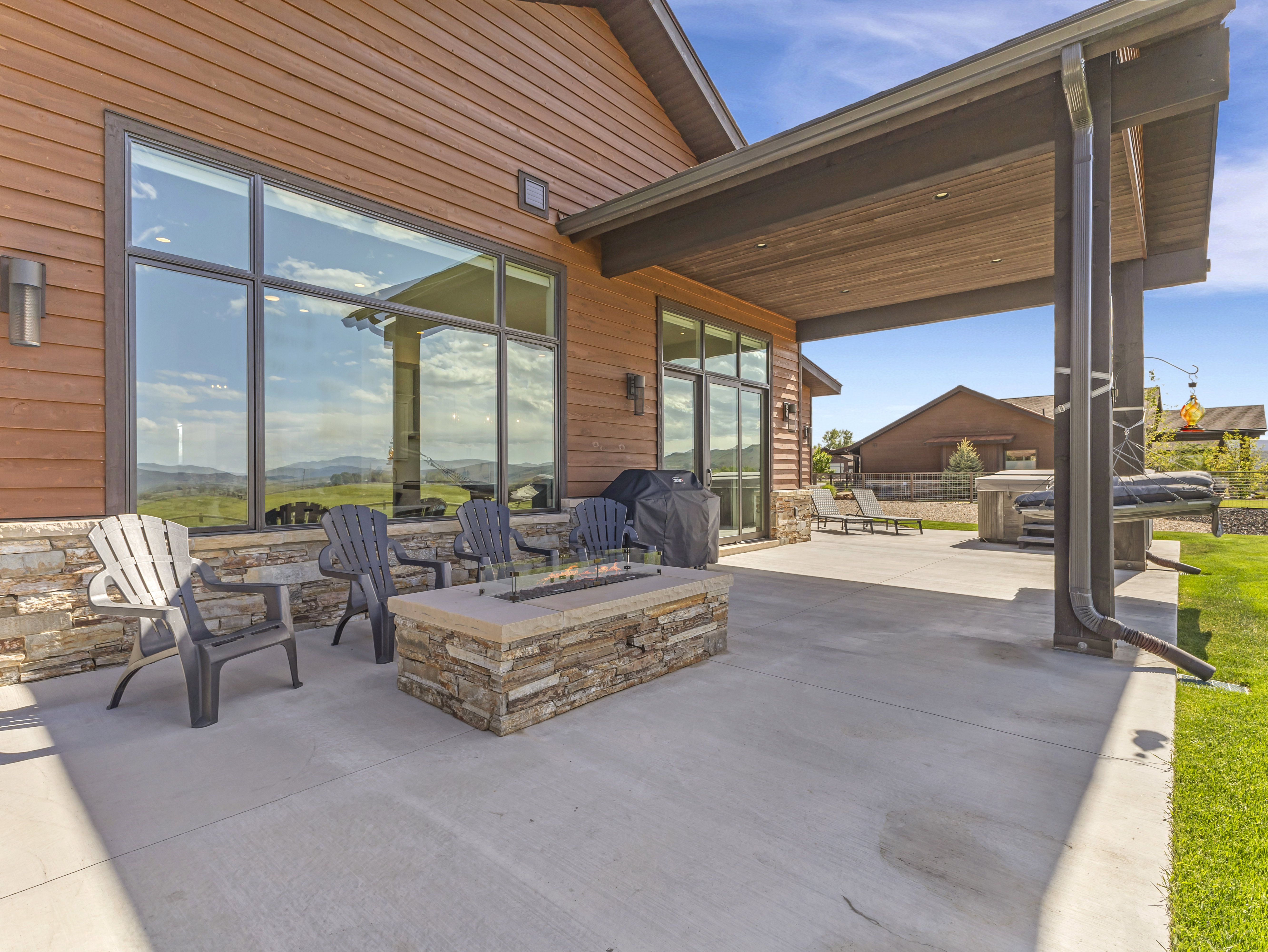 Expansive concrete patio with a built-in stone fire pit