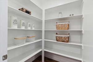 Spacious pantry featuring multiple tiers of white shelving, offering extensive storage capacity