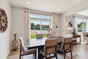 Open-concept dining area featuring wood-finish flooring and recessed lighting