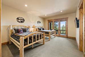 Spacious room featuring wood-frame beds, recessed lighting, and a neutral carpet
