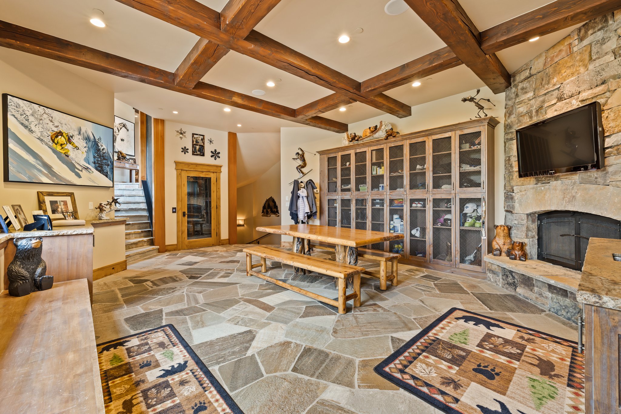 Spacious room featuring flagstone flooring and a coffered ceiling with exposed wood beams