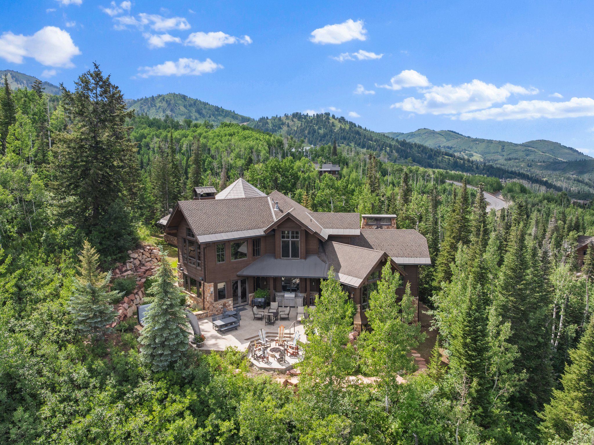 Multi-level mountain-style residence featuring a prominent stone facade and dark wood siding