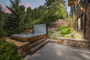 Outdoor spa with wood-finish siding set on a stone-faced concrete patio