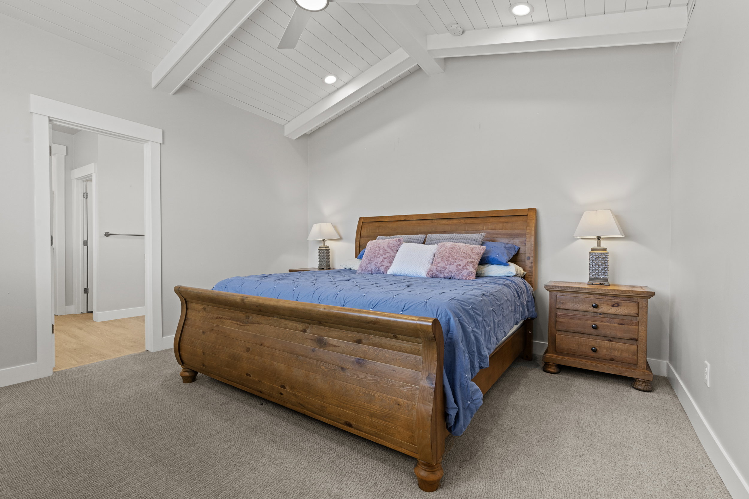 Vaulted ceiling with white shiplap and exposed beams, recessed lighting, and a ceiling fan