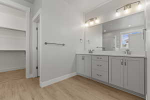 Bathroom featuring a dual vanity with light grey cabinetry, white countertops, and chrome fixtures