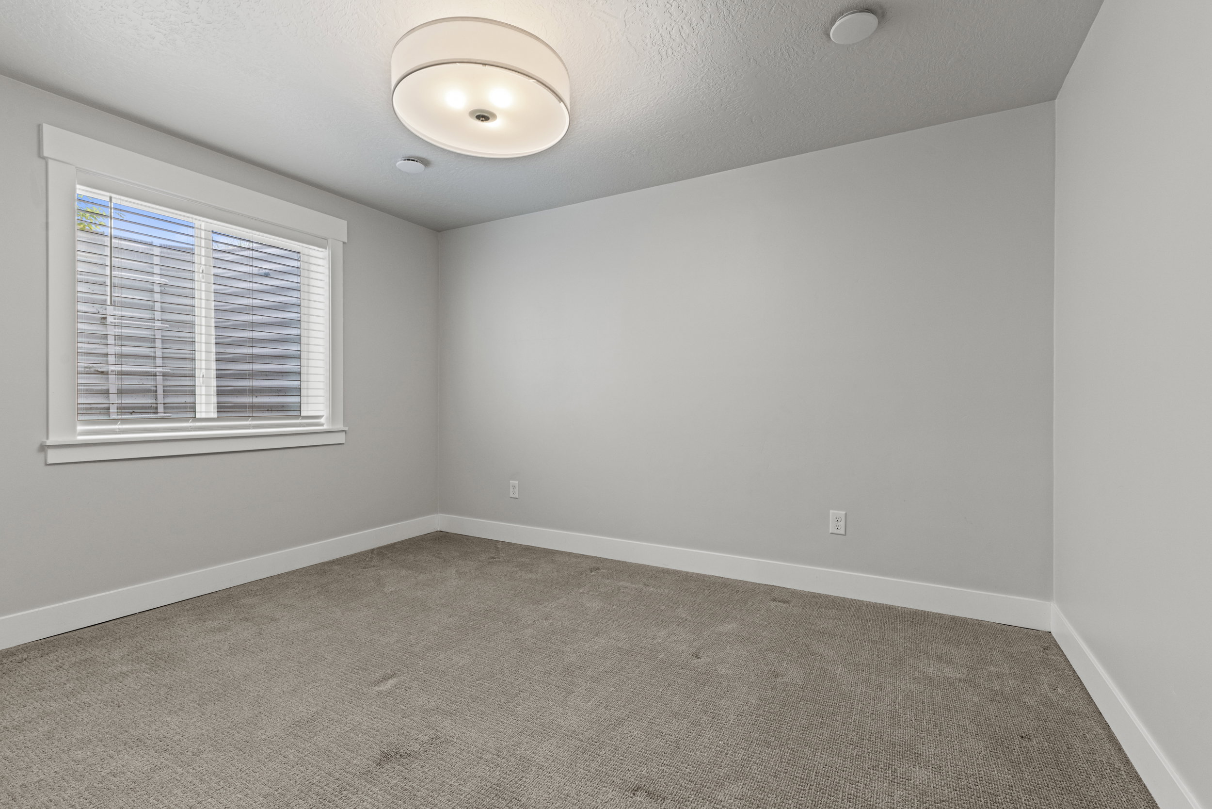 Bedroom featuring neutral-toned wall paint and textured carpeting