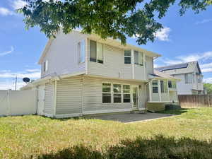 Rear exterior featuring light-colored horizontal siding and multiple windows