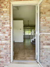 Tiled entryway with brick exterior framing the entrance