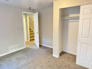 Carpeted interior space with a built-in closet featuring bi-fold doors and shelving