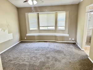 Spacious room featuring a bay window with a built-in bench, ceiling fan with integrated lighting, and carpet flooring