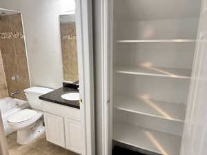 Bathroom featuring a white vanity with a dark granite-style countertop and an integrated sink