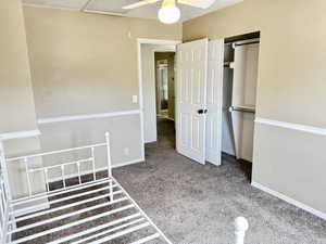 Carpeted room with neutral painted walls featuring white chair rail molding