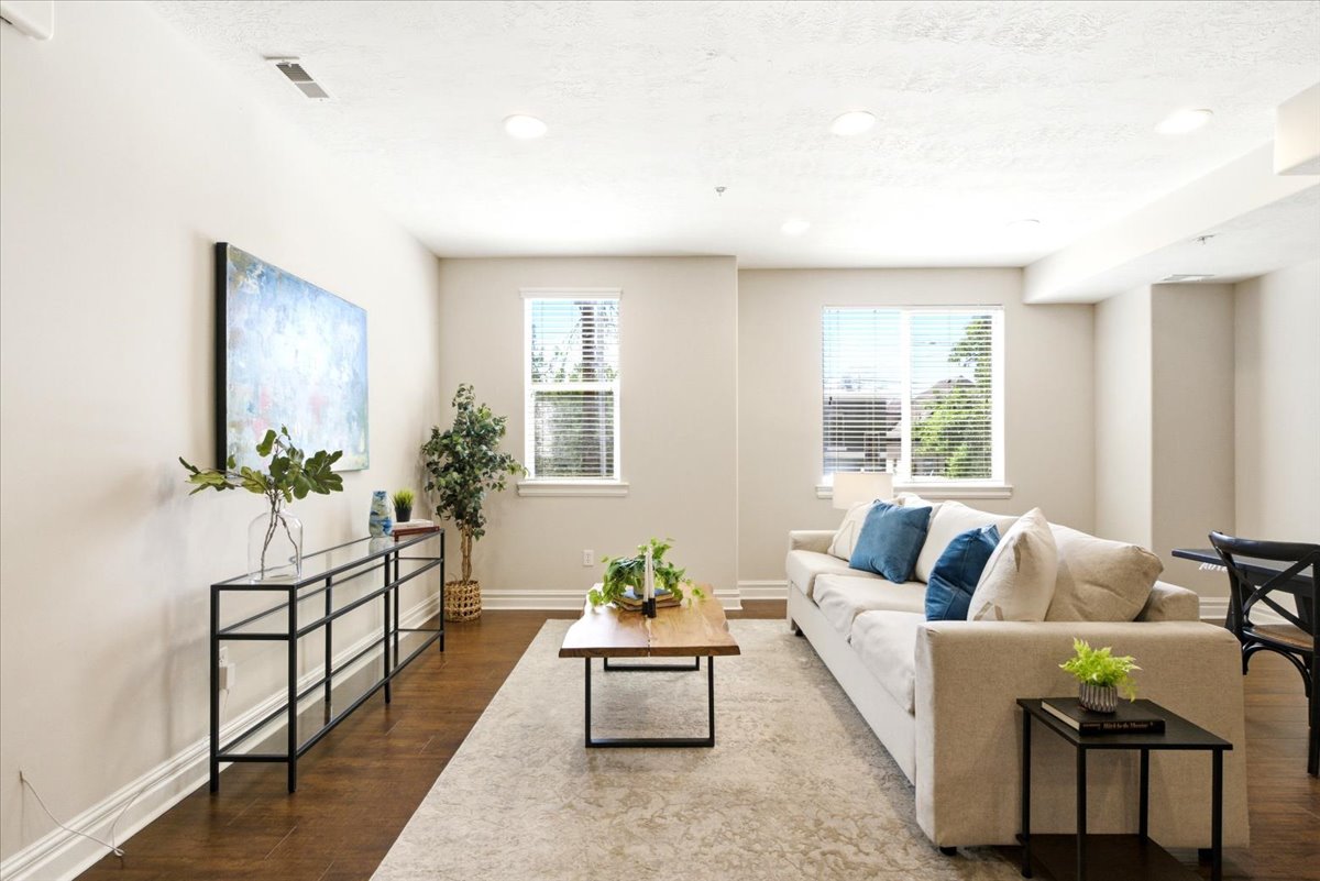 Spacious living area featuring wood-finish flooring, recessed lighting, and crown molding
