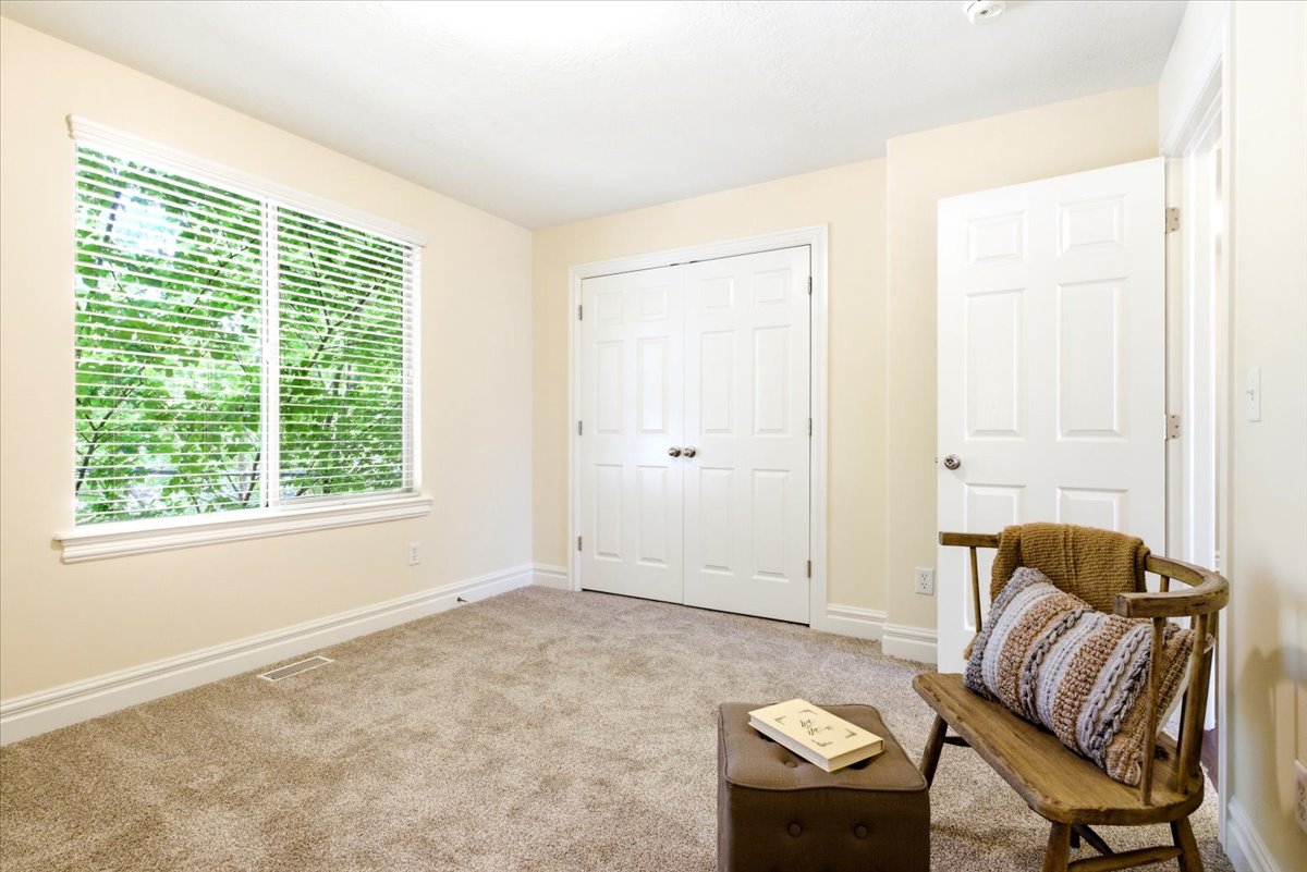 Bright room with a large window featuring horizontal blinds, neutral wall paint, and white baseboards