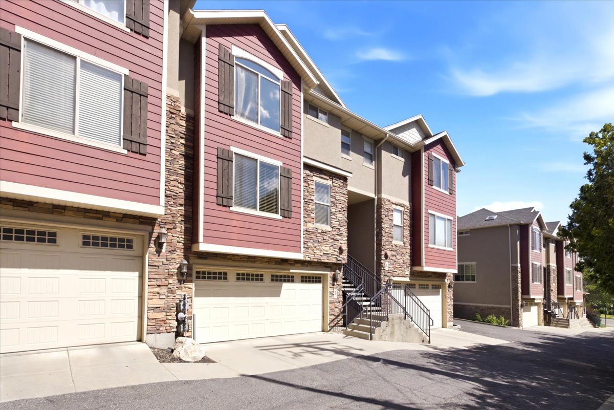 Multi-story townhomes featuring stone veneer and horizontal siding exteriors