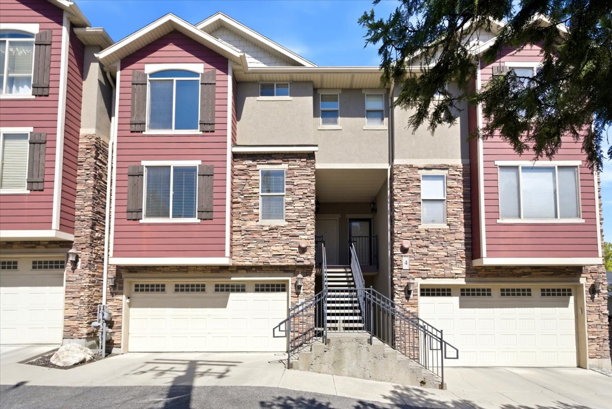 Multi-level exterior featuring a combination of stone veneer, stucco, and horizontal siding