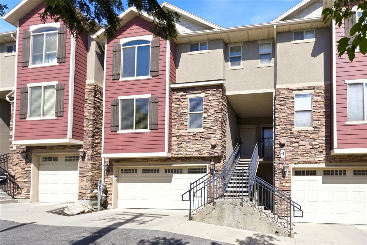 Multi-level townhome exterior featuring stone accents and horizontal siding