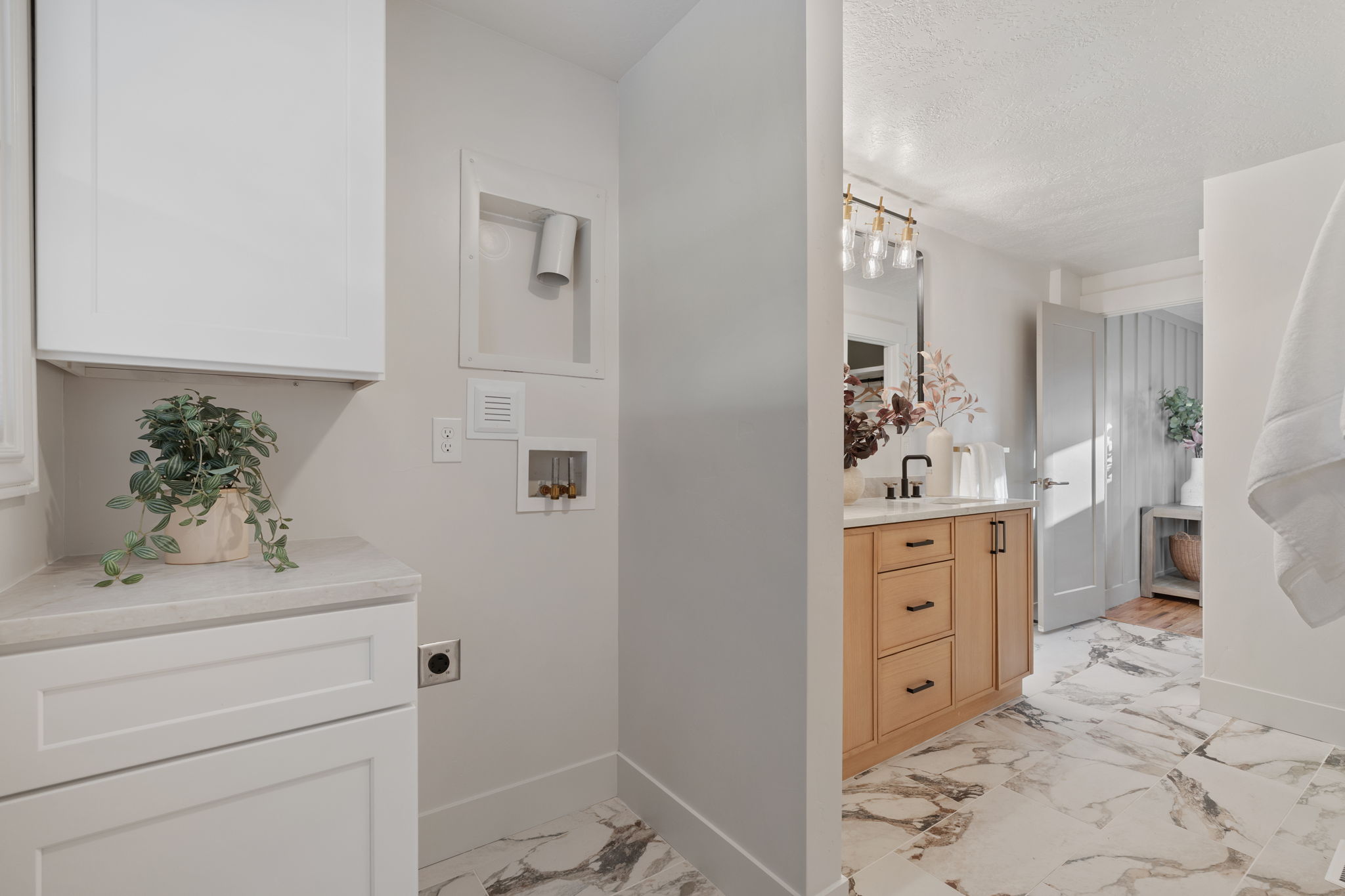 Bathroom featuring a natural wood vanity with a light-colored countertop, a rectangular mirror, and a matte black faucet