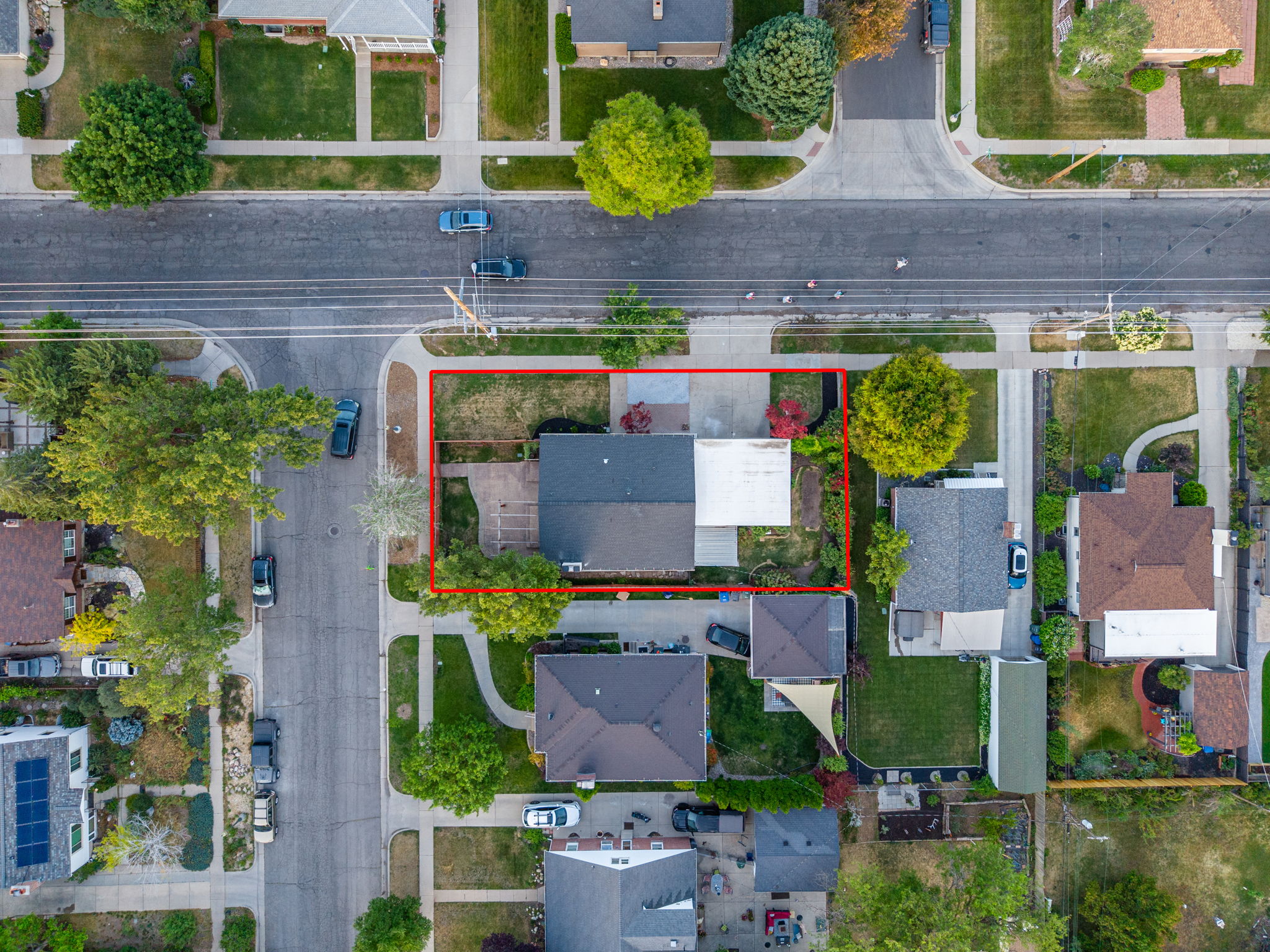 Aerial perspective showcasing a property with a dark-pitched roof and a light-colored flat roof section