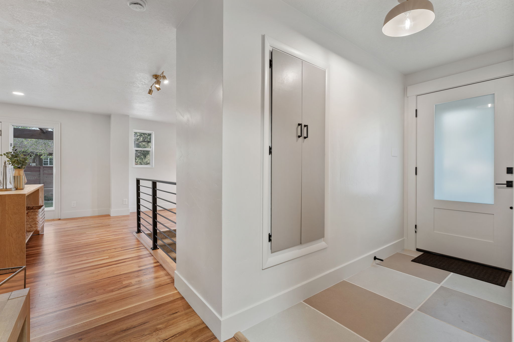 Entryway with a solid panel door featuring a frosted glass insert and a stylish pendant light
