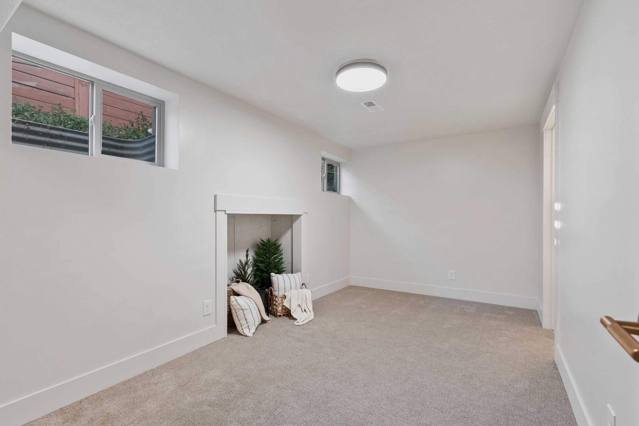 Carpeted room featuring a built-in niche, white baseboards, and a flush-mount ceiling light