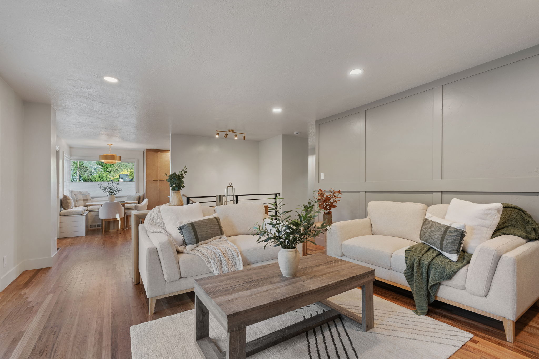 Living area with wood-finish flooring, recessed lighting, and a decorative paneled accent wall