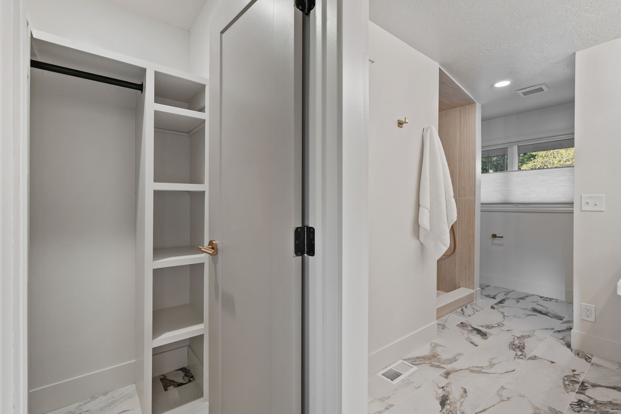 White built-in shelving with hanging rod, offering organized storage