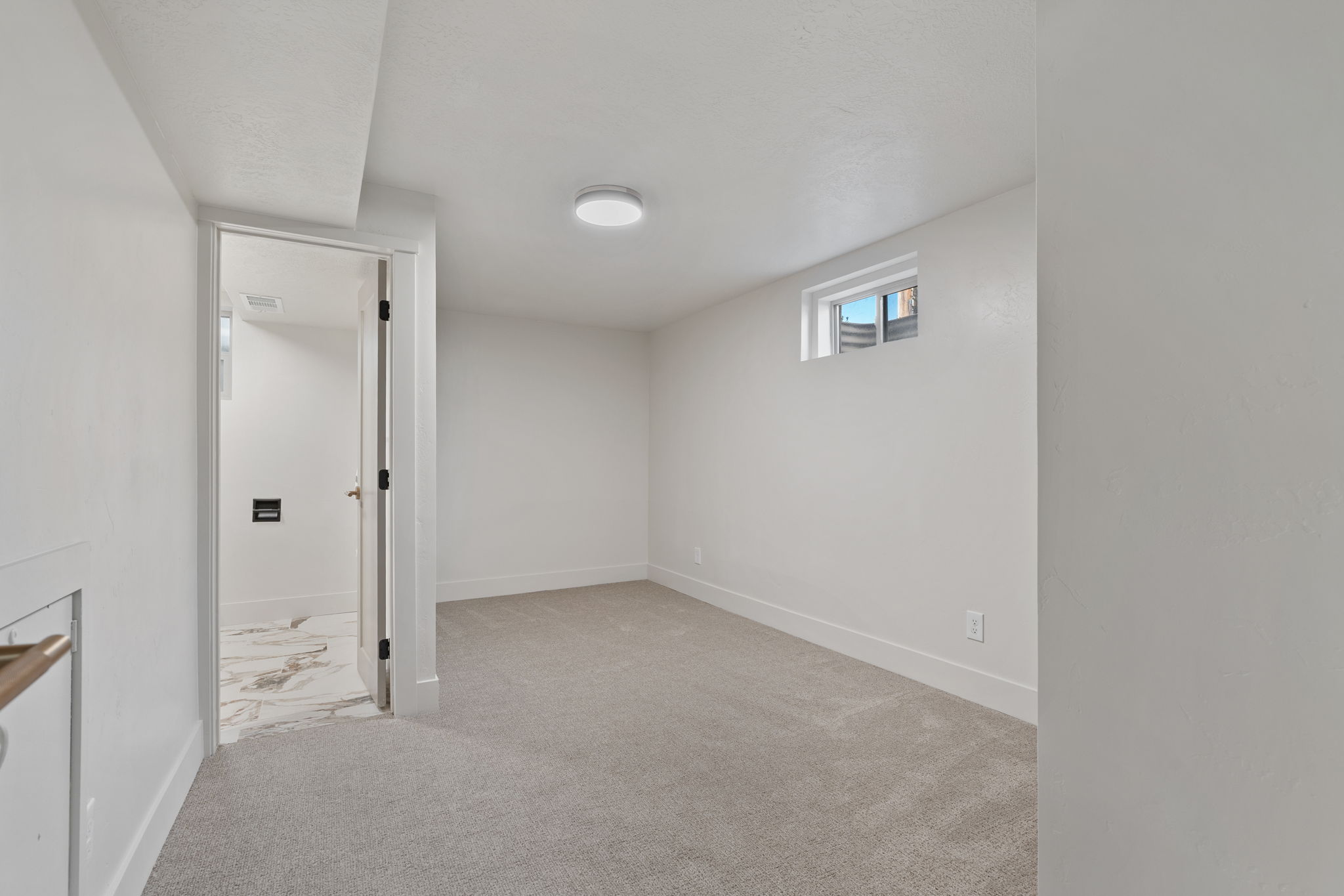 Carpeted room with white walls, a flush-mount ceiling light, and a horizontal window