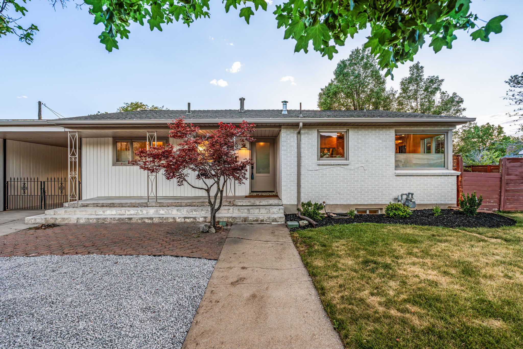 Ranch-style exterior featuring a combination of light-colored brick and vertical siding